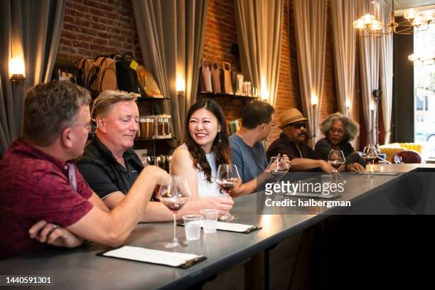 cheerful people drinking pinot noir at wine tasting - wine bar stock pictures, royalty-free photos & images