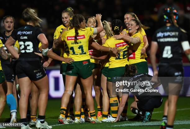 Tarryn Aiken of Australia celebrates with teammates after scoring their team's first goal during the Women's Rugby League World Cup Group B match...