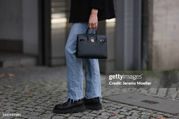 Mandy Bork wearing Saint Laurent black blazer, Hermes black leather Birkin bag, Bottega Veneta black leather boots, Celine black and gold logo belt,...