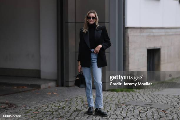 Mandy Bork wearing Saint Laurent black blazer, Hermes black leather Birkin bag, Bottega Veneta black leather boots, Celine black and gold logo belt,...