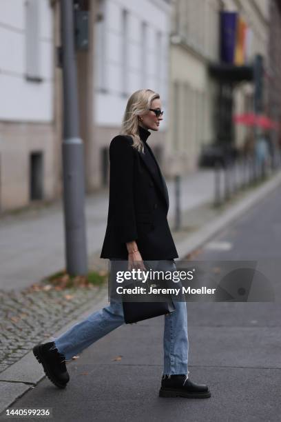 Mandy Bork wearing Saint Laurent black blazer, Hermes black leather Birkin bag, Bottega Veneta black leather boots, Celine black and gold logo belt,...