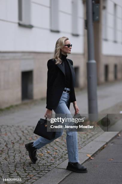 Mandy Bork wearing Saint Laurent black blazer, Hermes black leather Birkin bag, Bottega Veneta black leather boots, Celine black and gold logo belt,...