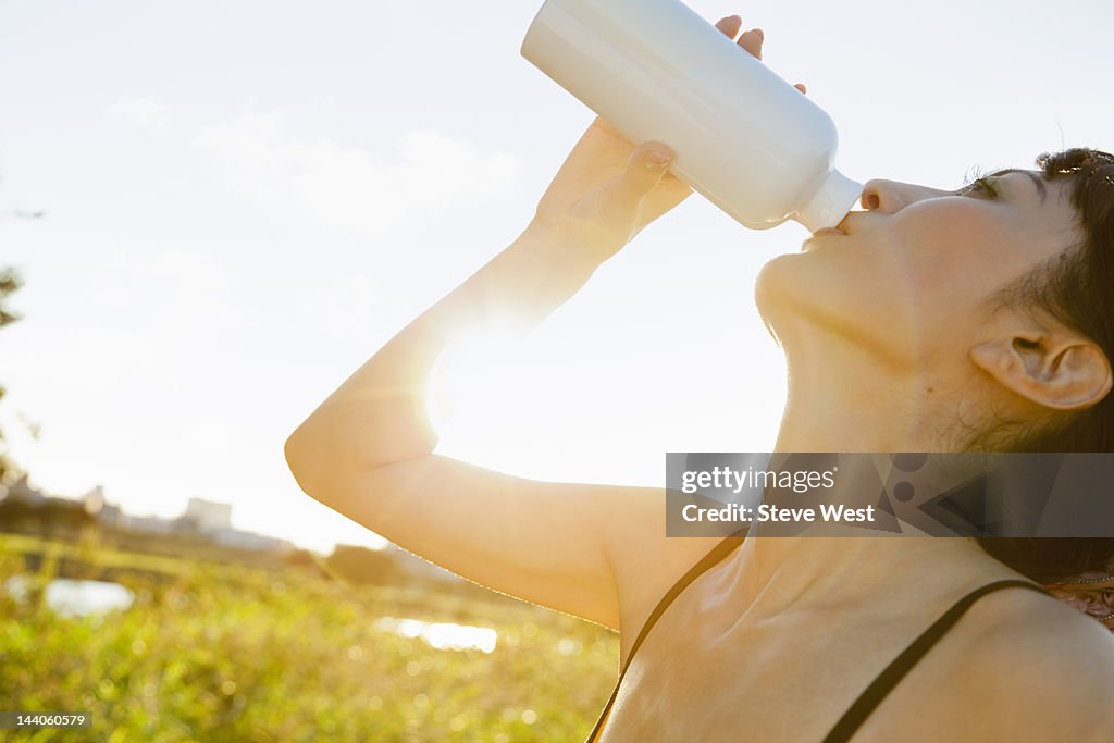 Athletic woman drinking from water bottle