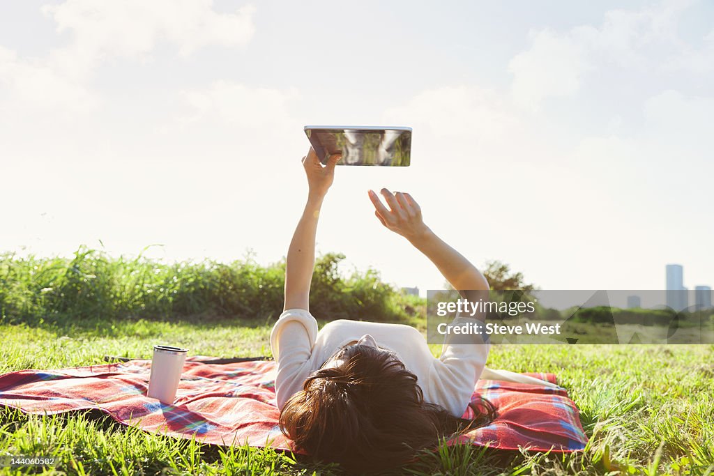 Woman lying down using digital tablet