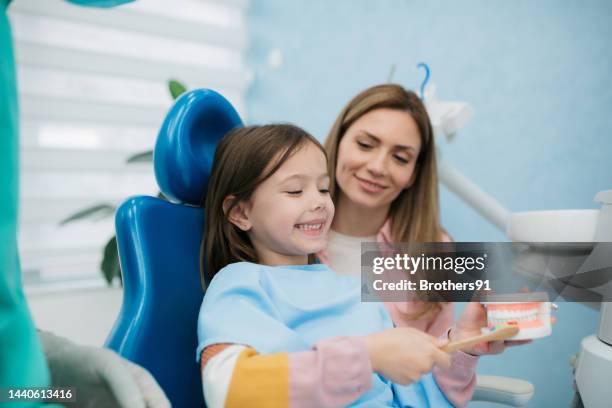 little girl visiting a dentist - human teeth stock pictures, royalty-free photos & images
