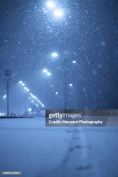 footprint of snowy road at night in city - 雪　降る ストックフォトと画像