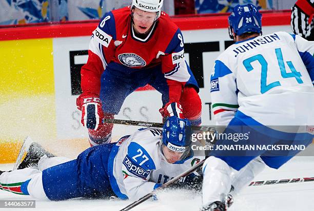 Italy's Thomas Larkin fights for the puck with Norway's Mads Hansen during a preliminary round match at the Ice Hockey World Championships in...