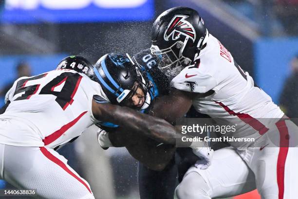 Rashaan Evans of the Atlanta Falcons and Lorenzo Carter of the Atlanta Falcons tackle Chuba Hubbard of the Carolina Panthers during the second...