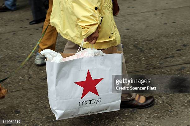 Woman carries a Macy's shopping bag in front of the flagship store on May 9, 2012 in New York City. Beating Wall Street's expectations, Macy's Inc....