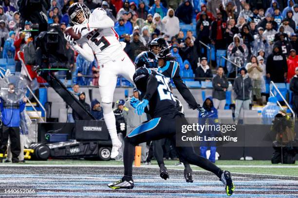 Drake London of the Atlanta Falcons catches a touchdown over Donte Jackson of the Carolina Panthers and Xavier Woods of the Carolina Panthers during...