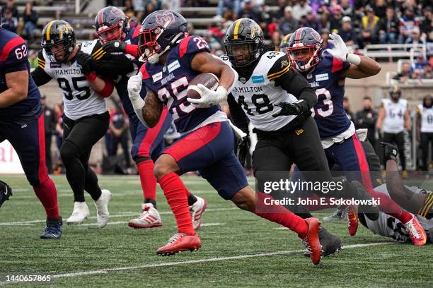 Walter Fletcher of the Montreal Alouettes tries to outrun Cedric Wilcots of the Hamilton Tiger-Cats on a rushing play at Percival Molson Stadium on...