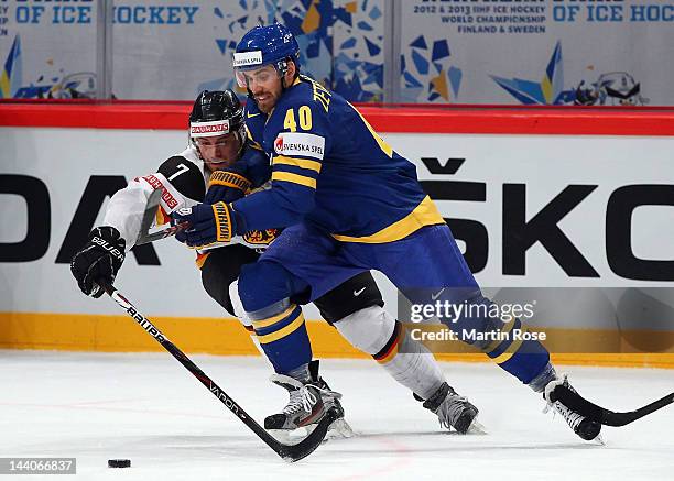 Henrik Zetterberg of Sweden and Niklas Kronwall of Germany battle for the puck during the IIHF World Championship group S match between Sweden and...