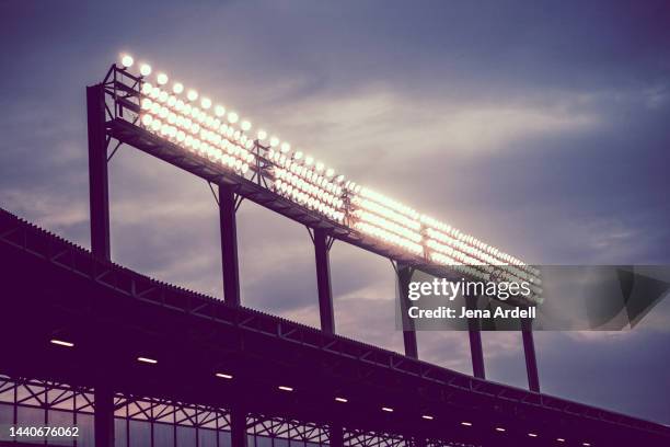 stadium lights at night, bright lights, electricity illuminating sky - stadio foto e immagini stock
