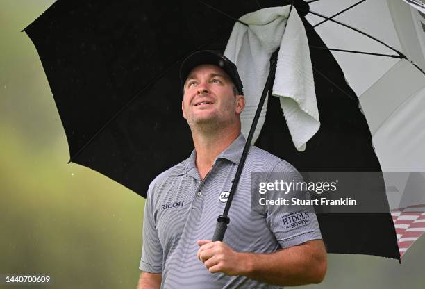 Ryan Fox of New Zealand shelters under an umbrella on the first hole during Day Two of the Nedbank Golf Challenge at Gary Player CC on November 11,...