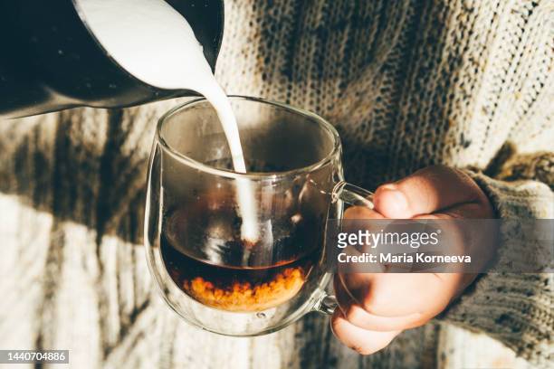 woman pouring milk into coffee while making cappuccino coffee. - coffee milk stockfoto's en -beelden