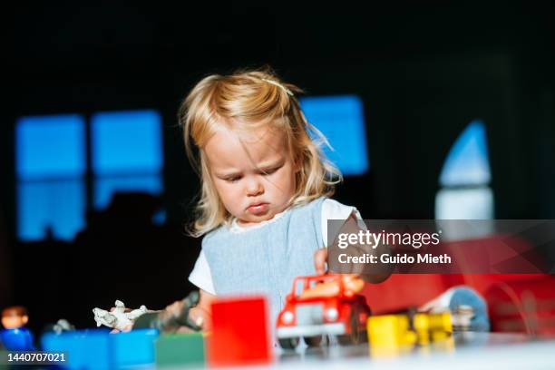 little child playing with toy blocks and little cars indoor. - toy cars photos et images de collection