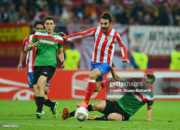 Adrian Lopez of Atletico Madrid is brought down by Inigo Perez of Athletic Bilbao during the UEFA Europa League Final between Atletico Madrid and...