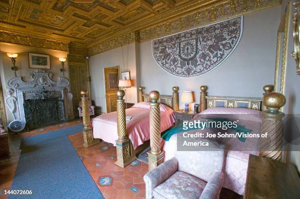 Interior of guest bedroom with displayed antique clothing of the day at Hearst Castle, "America's Castle," San Simeon, Central California Coast