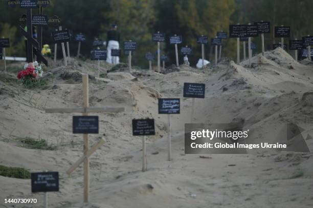 Religions crosses and tablets on the graves at the site of a mass burial on October 7, 2022 in Lyman, Ukraine. The exhumation was completed at the...