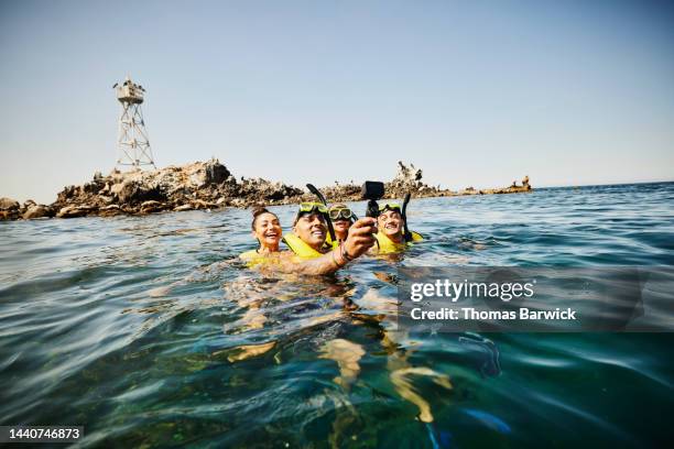 wide short of family taking selfie with action camera while snorkeling - mother with daughters 12 16 stock-fotos und bilder