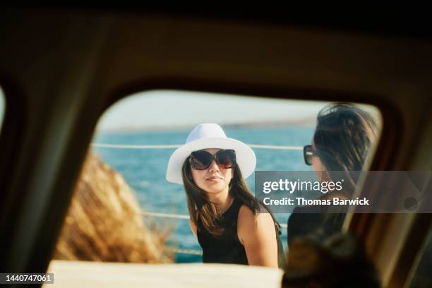 medium shot of woman sitting on deck of sailboat with family - family yacht stock pictures, royalty-free photos & images