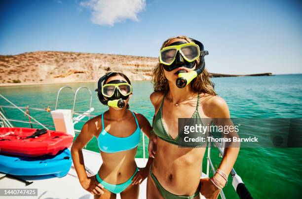 Medium shot of girls in masks and snorkels on deck of sailboat