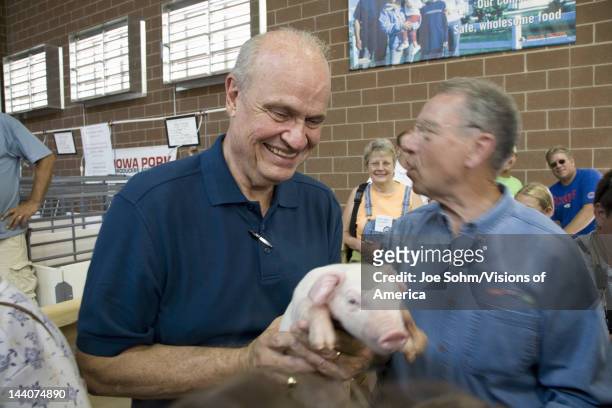 Former US Senator and actor of Law & Order, Fred Thompson holding baby pig with US Senator from Iowa, Republican Chuck Grassley, at Iowa State Fair...