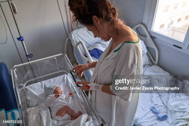 mother showing her newborn baby by videoconference to her family - prenatal care stockfoto's en -beelden