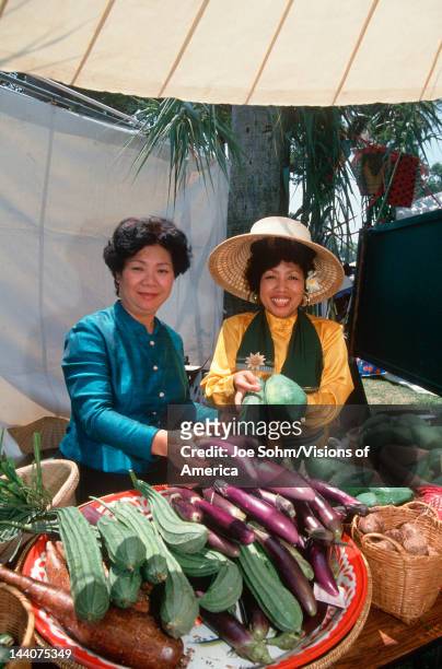Two Thai women selling vegetables at the Lotus Festival in Echo Park, Los Angeles, CA