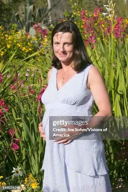 Pregnant 40 year old mother to-be poses in gardens in springtime in Ojai, California