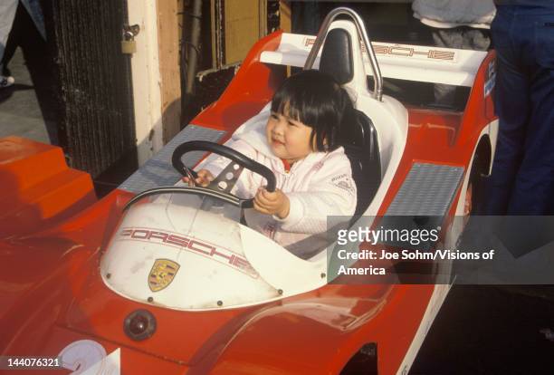 An Asian-American child driving a bumper car at the Santa Monica Pier, CA