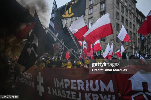 Members of far right associations light flares and shout slogans as they take part in the Independence day march organized by ultra Catholic right...