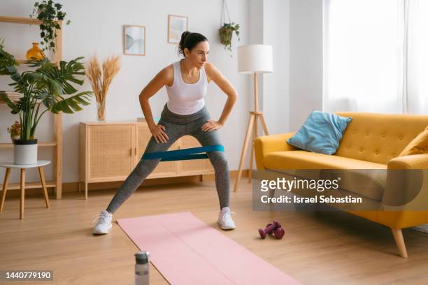 woman using an elastic band to exercise at home. - aerobics 個照片及圖片檔