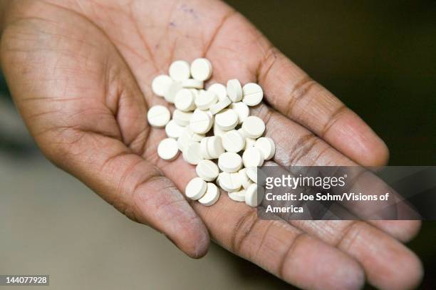 Closeup of a hand holds AIDS pills at the Pepo La Tumaini Jangwani, HIV/AIDS Community Rehabilitation Program, Orphanage & Clinic, Pepo La Tumaini...