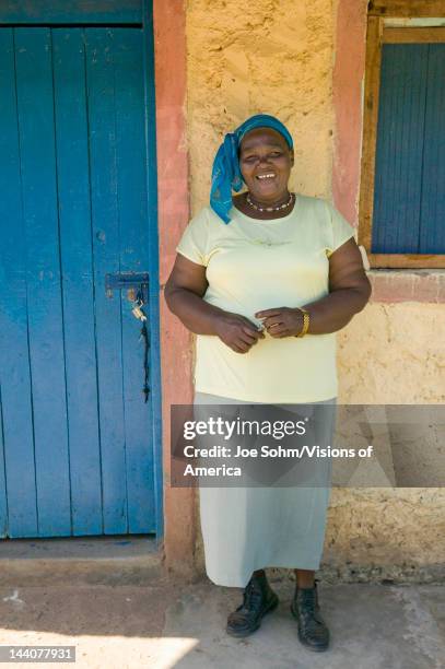 Kenyan woman smiles in front of Pepo La Tumaini Jangwani, HIV/AIDS Community Rehabilitation Program, Orphanage & Clinic, Pepo La Tumaini Jangwani...