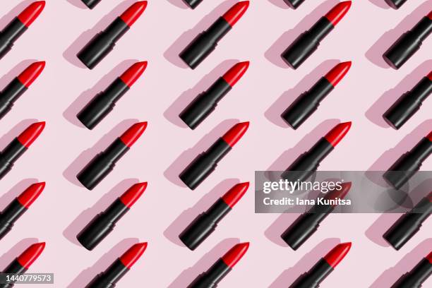red lipsticks, lip gloss on trendy pastel pink background. cosmetic products. makeup accessories. skin care. beauty 3d pattern. - 赤の口紅 ストックフォトと画像