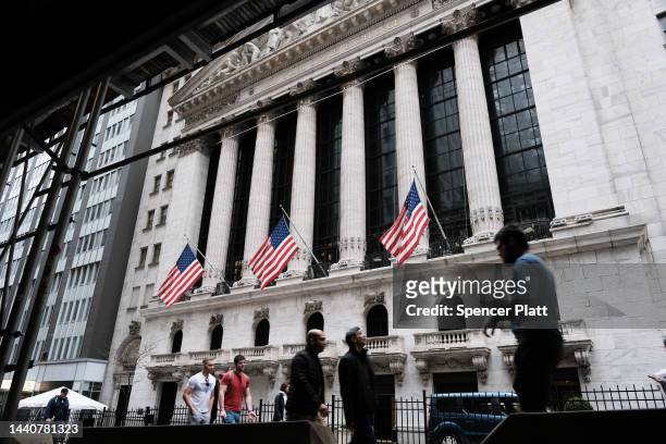People walk by the New York Stock Exchange on November 11, 2022 in New York City. Stocks were mixed in morning trading after surging over 1000 points...