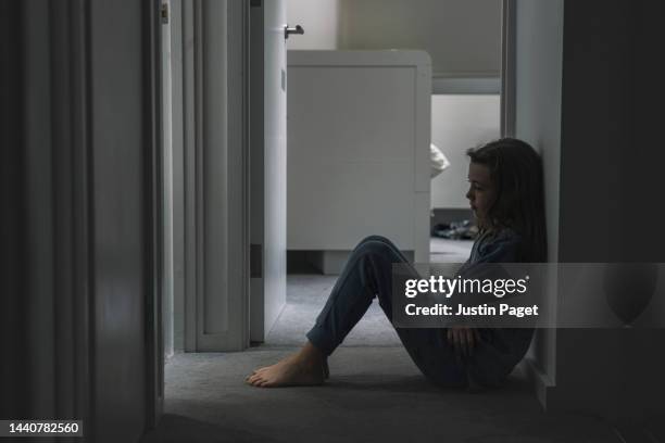 young girl sitting on landing floor - negative emotion - child mental health wellness stock-fotos und bilder