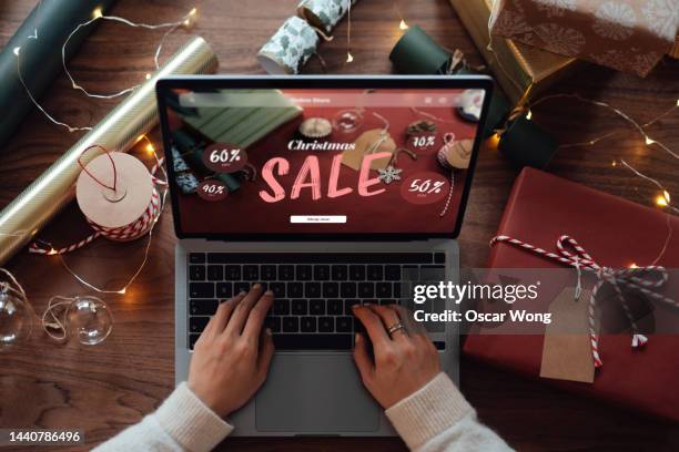 overhead shot of young woman doing online christmas shopping on laptop - sale bildbanksfoton och bilder