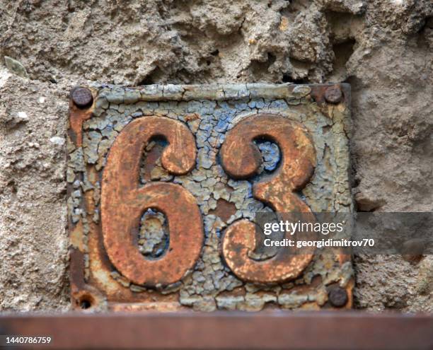 Vintage grunge square metal rusty plate of number of street address with number.