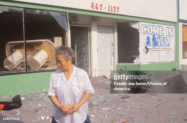 Asian woman standing in front of store looted during 1992 riots, South Central Los Angeles, California