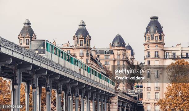 metro train of famous pont de bir-hakeim bridge in paris - lieu touristique photos et images de collection