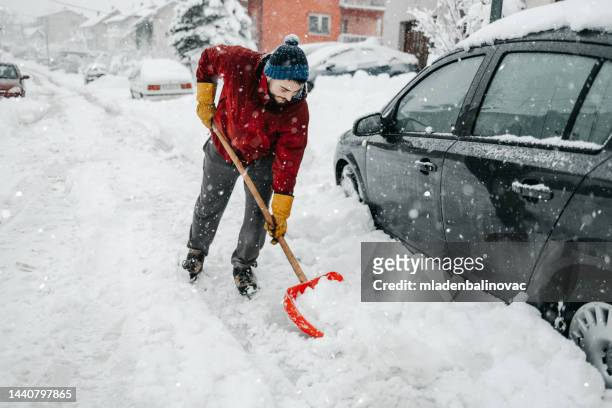 man with snow shovel - snow shovel man stock pictures, royalty-free photos & images