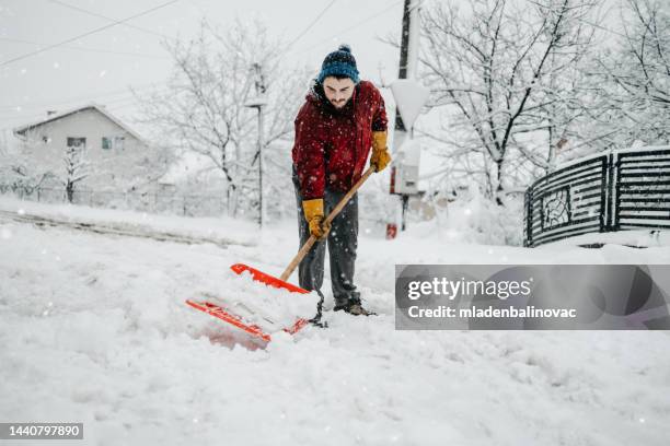 man with snow shovel - shoveling driveway stock pictures, royalty-free photos & images