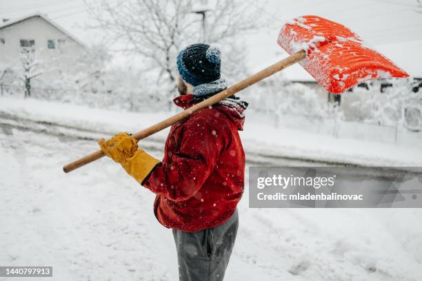 mann mit schneeschaufel - spaten stock-fotos und bilder