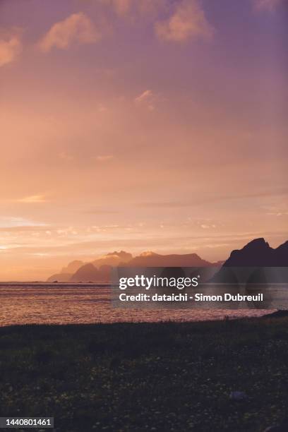 lofoten seen from the northern coast of værøy during midnight sun - sole di mezzanotte foto e immagini stock