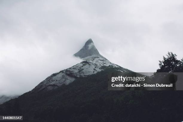 clouds around stetind mountain peak - stetind stock pictures, royalty-free photos & images