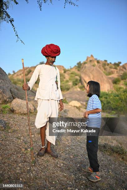 tourist girl interacting with a senior rabari man - nomad cattle herder from rajasthan stock-fotos und bilder