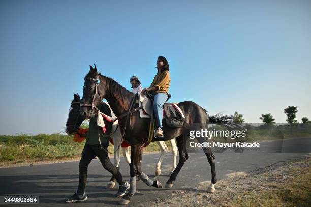 tourist mother and daughter riding a horse - hairy indian men stockfoto's en -beelden