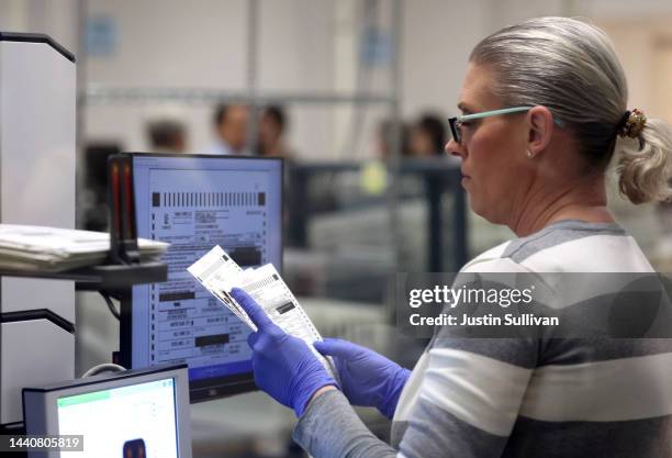 An election worker scans ballots at the Maricopa County Tabulation and Election Center on November 11, 2022 in Phoenix, Arizona. Ballots continue to...